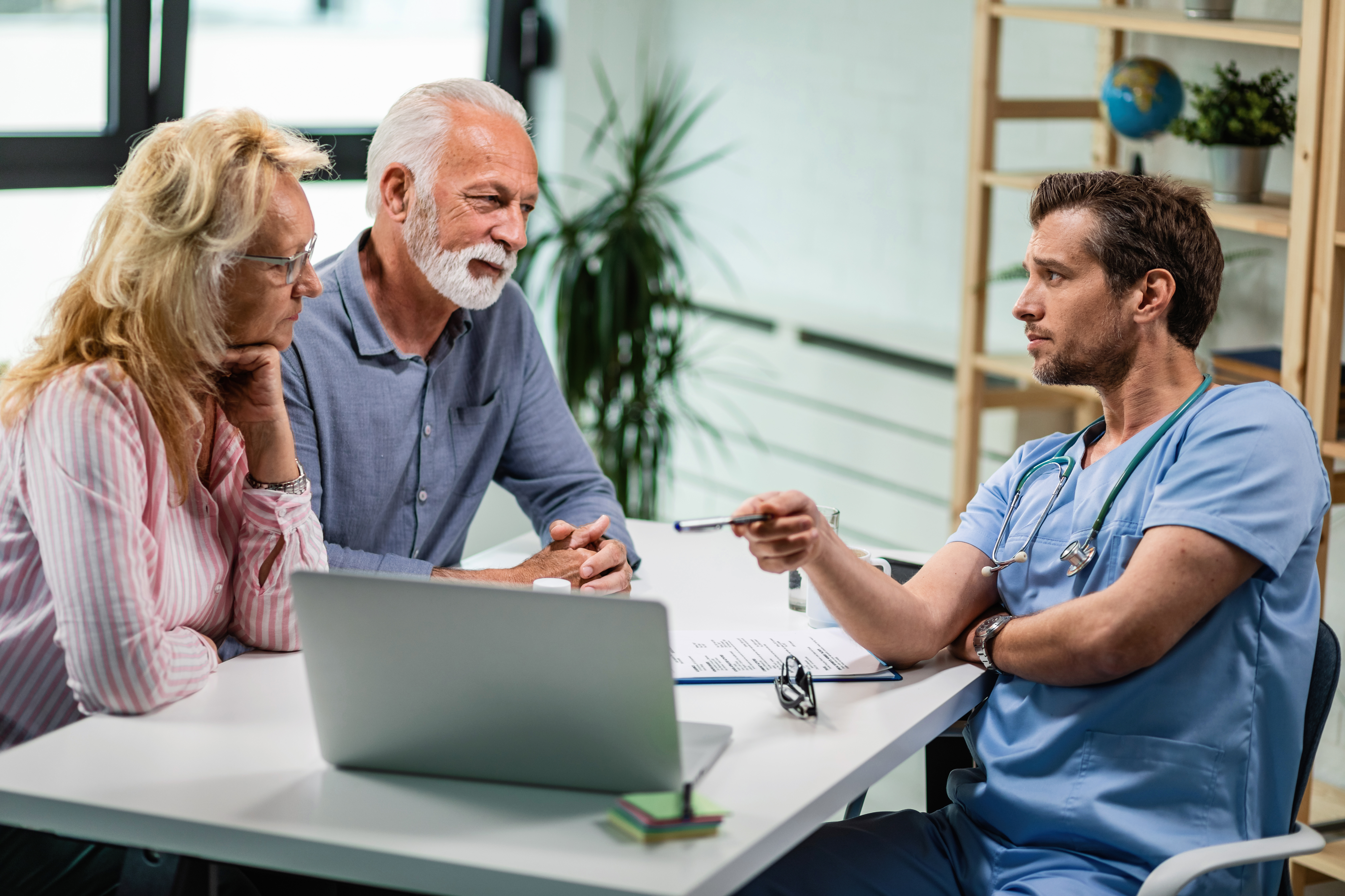 A doctor talking to a senior couple.